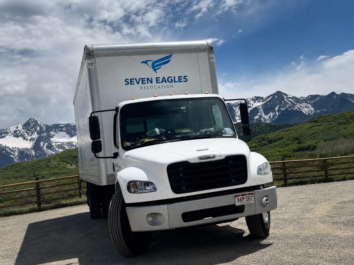 Seven Eagles Relocation box truck parked at a Colorado mountain overlook, the eagle logo on its side